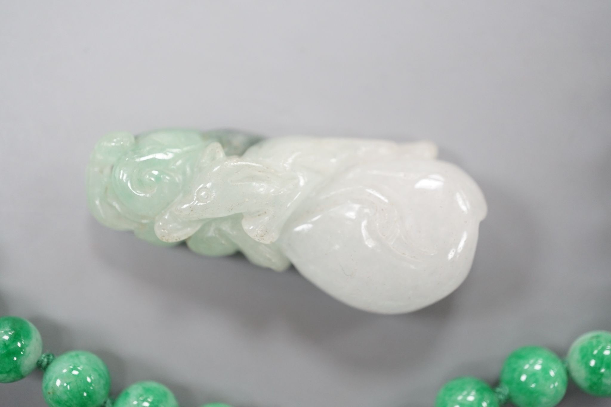 A jade bead necklace hung with three jade carvings, 49cm and three other jade carvings.